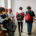 A group of five students sitting near a staircase